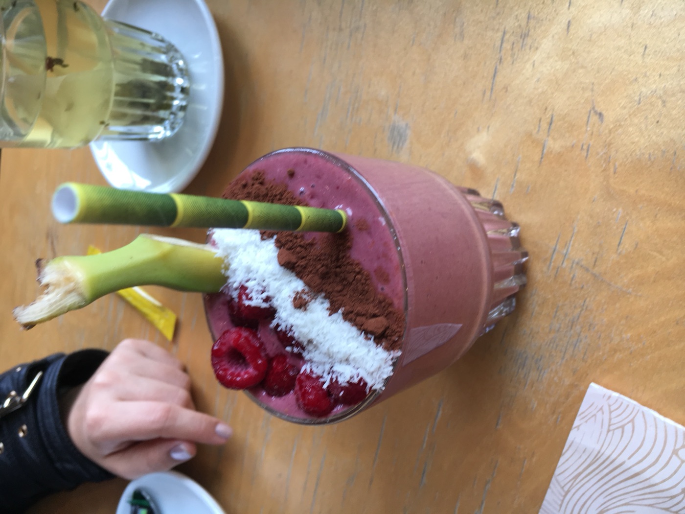 A berry smoothie topped with raspberries, coconut and chocolate