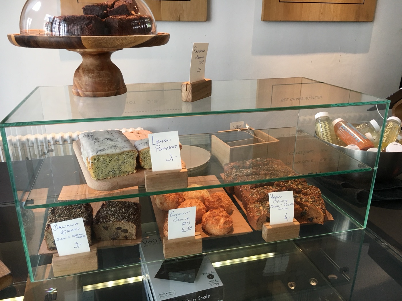 A café counter displaying banana bread, lemon poppy-seed cake and cookies