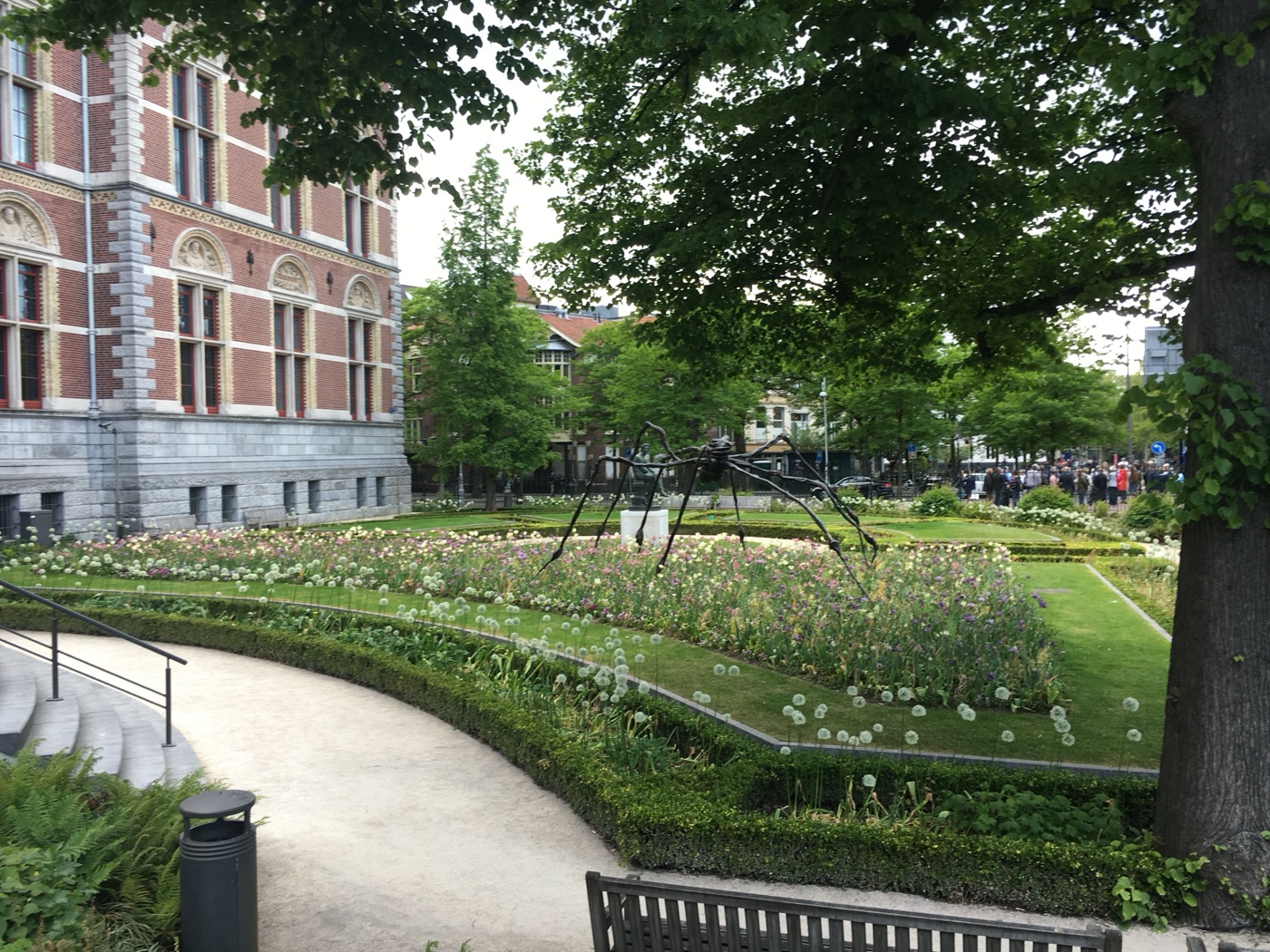 A giant Louise Bourgeois spider sculpture among spring flowers in the Rijksmuseum gardens